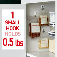 Small white wire hook holding spice packets inside a kitchen cabinet