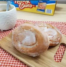 Glazed honey buns on a wooden board with white topping