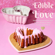 Pink heart-shaped fluted baking pan with white nonstick interior coating