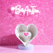 Heart-shaped fluted baking pan with a pink outer shell and white interior