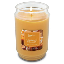Lit salted caramel butterscotch candle in clear glass jar, single wick