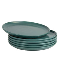 Emerald green round stoneware dinner plate stack showing side profile and raised rim