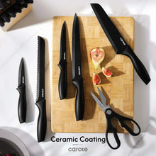 Assorted black ceramic-coated knives with kitchen shears on a wooden cutting board