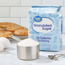 Granulated sugar box with scoop of white sugar and small measuring tools