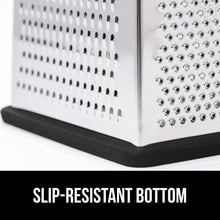 Stainless steel grater with black slip-resistant base and shredding holes close-up
