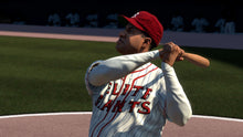 Baseball player in white pinstripe uniform and red cap holding a bat
