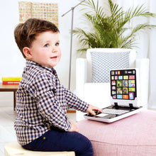Toddler playing with Infinifun 2-in-1 toy tablet on a sofa