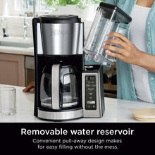 Black and stainless coffee maker with pull-out water reservoir and glass carafe