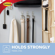 Clear wire toggle wall hooks arranged on a wall holding items