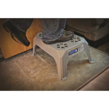 Gray plastic step stool on tile floor with perforated step top