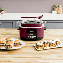 Cherry tarte Ninja multi-cooker with glass lid and red utensil resting on top