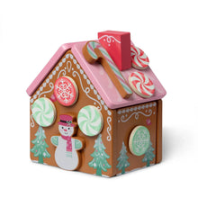 Pink wooden gingerbread house toy with doors, windows, and peppermint lacing pieces