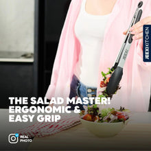 Kitchen tongs with black silicone tips serving salad from a bowl