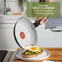 Black ceramic non-stick sauté pan with food, side handles, and short rim