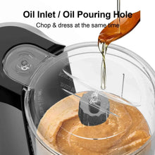 Food chopper lid with oil pouring hole over bowl, adding oil while chopping