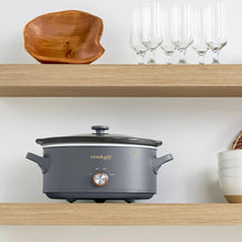 Gray Crock-Pot manual slow cooker with lid and bronze control knob, side handles visible