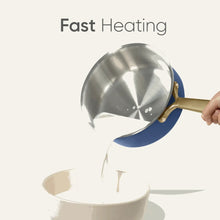 Blue tri-ply stainless saucepan pouring liquid, with domed lid and gold handle
