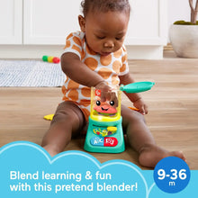 Turquoise musical smoothie maker toy with smiley face as baby sits and reaches forward.