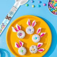 Assorted pastel bunny M&M's candies on a plate with M&M's candy cane