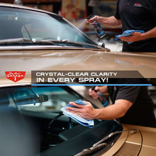 Car wash kit spray bottle and microfiber cloth cleaning a car windshield
