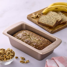 Rose-gold nonstick loaf pan filled with banana bread, loaf centered