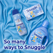 Snuggle Blue Sparkle scent booster bottle, sachet, and cap on blue fabric