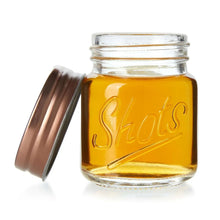 Mini mason jar shot glass with copper lid, amber liquid, side view ajar
