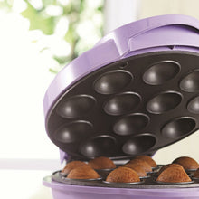 Electric cake pop maker open with dark mold cavities and browned batter
