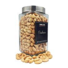 Glass canister of cashews with front label and cashews scattered