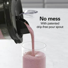 Blender with black base pouring pink smoothie from drip-free pour spout into glass