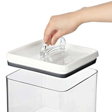 Airtight bagel food storage container with lid being lifted, clear sides, white top, dark trim