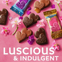 Assorted chocolate hearts and Ghirardelli candy bars on pink packaging