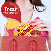 Heart-shaped jelly beans candy in pink bag held over a gift basket
