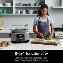 Gray multi-cooker on kitchen counter while preparing food on a cutting board