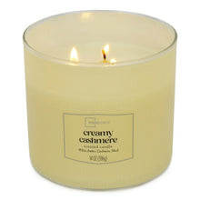 Creamy cashmere scented candle in cream wax with lit wicks and front label
