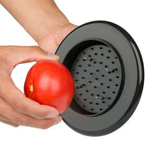 Adjustable chef’s mandoline slicer with round blade drum holding a tomato