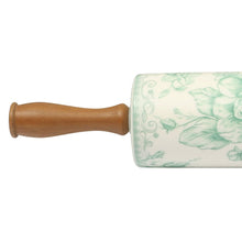 Ceramic rolling pin with wood handle and green floral pattern on barrel