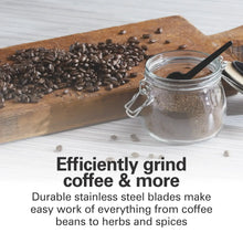 Electric coffee grinder beside coffee beans and a jar of coffee grounds