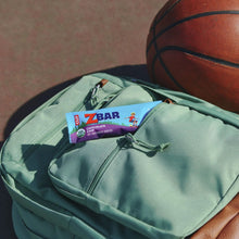 Zbar chocolate chip snack bar peeking from a light green backpack pocket
