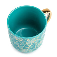 Teal ceramic mug with gold floral exterior and glazed interior