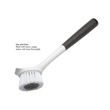 Round angled sink brush with white bristles and black soft-touch handle