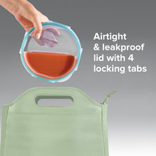 Round glass storage container with blue lid and four locking tabs, held by hand