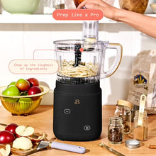 Black food processor with clear bowl, chopping blade, and food pusher