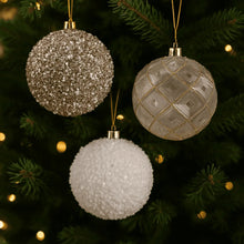 Three shatterproof Christmas ornaments: gold glitter, white textured, and gold geo sphere