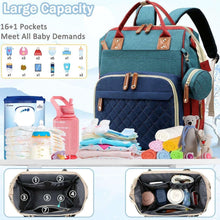 Blue baby diaper bag backpack with quilted front, two top handle straps, and side bottle pocket.
