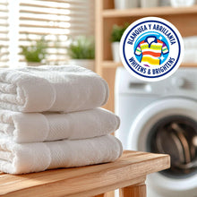 Folded white towels on wooden rack with laundry wash badge