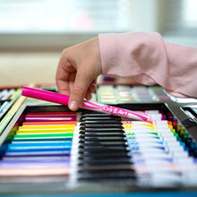 Hand holding a pink colored pencil over an open drawing set