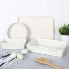 White 4-piece metal bakeware set with round dish, large rectangular tray, and rectangular baking pan