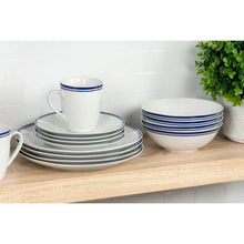 Stacked ceramic plates and bowls with blue stripe rims, plus blue-trim mugs