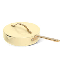 Buttercream covered saucepan with gold handle and strainer lid